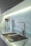 The glass wall and stainless counter add contemporary elegance.